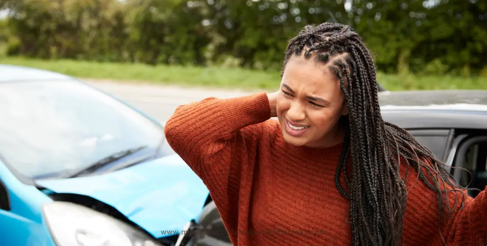 | Person in orange sweater standing near damaged cars after traffic accident, illustrating nerve damage in car accidents