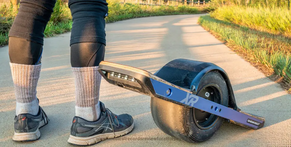 Person standing beside one-wheel electric skateboard on path representing Onewheel lawsuit