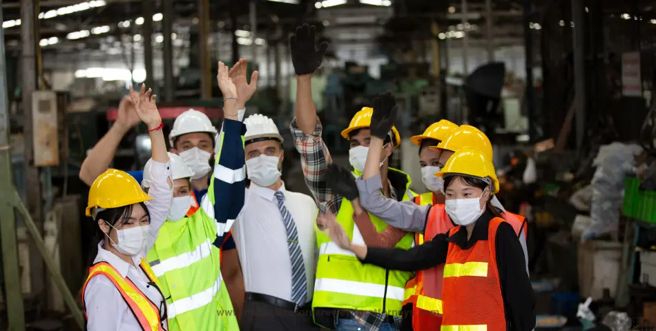 Industrial workers in helmets celebrating in factory representing workers’ compensation bill review