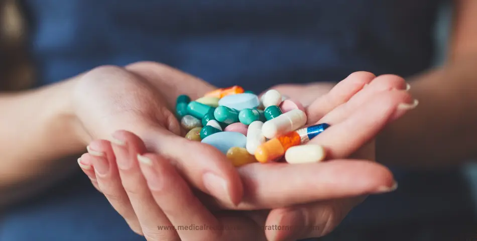 Close-up of hands holding a variety of colorful pills and capsules against a blurred background reprsents mass tort litigation.